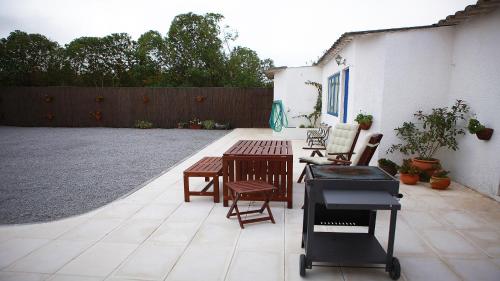 a patio with a grill and a table and chairs at Casal Do Góis Guest House in Atouguia da Baleia