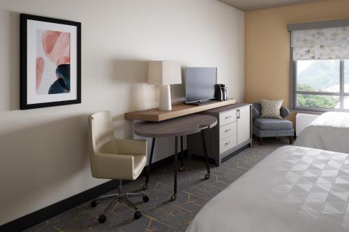 Habitación de hotel con escritorio, ordenador y cama en Holiday Inn Cleveland-Mayfield, an IHG Hotel, en Mayfield