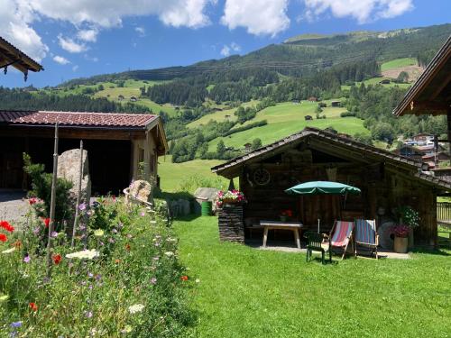 uma casa com uma mesa e cadeiras na relva em Ferienwohnung Lerchenhof em Wald im Pinzgau