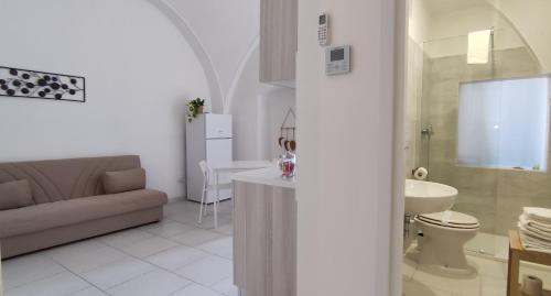 een woonkamer met een bank, een toilet en een wastafel bij Appartamenti Boho Chic in Sannicandro di Bari