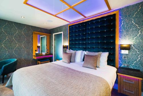 a bedroom with a large bed with a large headboard at Church Suites by The Cranleigh Boutique in Bowness-on-Windermere