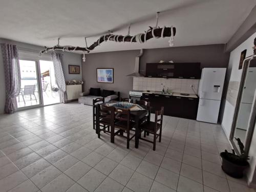 a kitchen and living room with a table and chairs at Elli's House in Keramotí