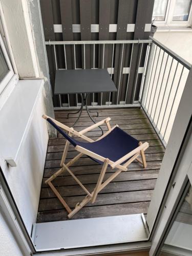 una silla en un balcón con mesa en Ruhige Ferienwohnung, en Rostock