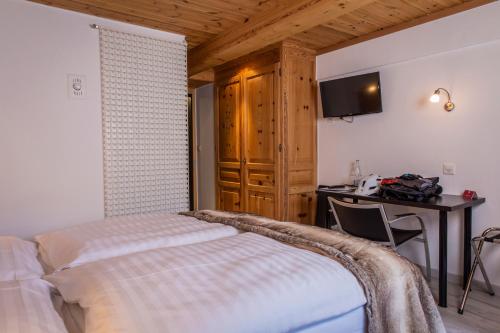 Una cama o camas en una habitación de Hôtel Alpina - Swiss Ski & Bike Lodge Grimentz