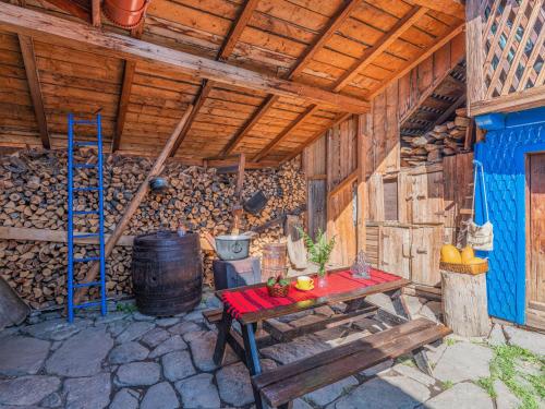 a wooden cabin with a table and a ladder at Casa de vacanta traditionala romaneasca in Schiuleşti