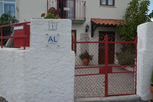 un cancello rosso di fronte a una casa bianca di Casa do Alfaiate 