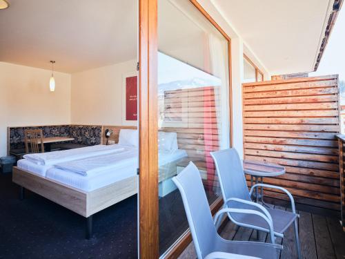 1 dormitorio con 1 cama, 2 sillas y mesa en Hotel Planai by Alpeffect Hotels, en Schladming