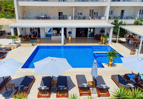 une image d'une piscine avec des chaises et des parasols dans l'établissement Hotel Perla, à Rogoznica