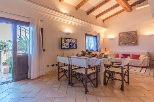 a living room with a table and chairs and a couch at Sardinia Home in Palau