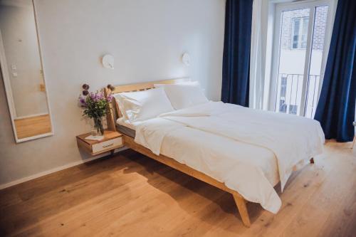 1 dormitorio con cama con espejo y ventana en The Layhead B&B, en Lübeck