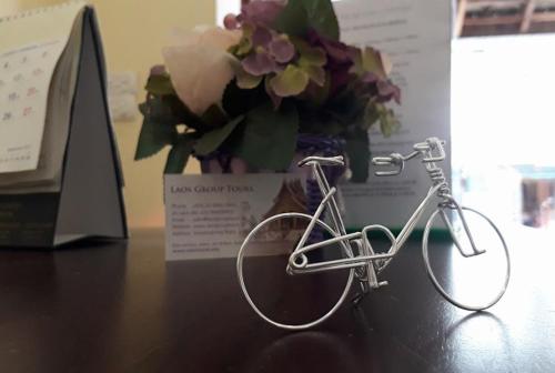 un vélo assis sur une table avec un vase de fleurs dans l'établissement Tony Central Hostel, à Luang Prabang