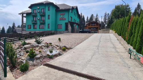 un edificio azul con una entrada delante de él en Kisva Hotel, en Yablunytsya