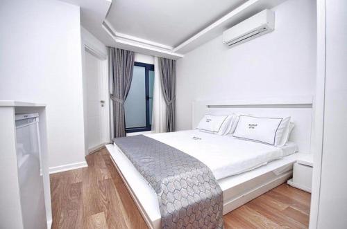 een witte slaapkamer met een groot bed en een raam bij Urla Marin otel in Izmir