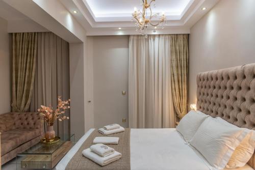 - une chambre avec un grand lit et un canapé dans l'établissement AGORA luxury BOUTIQUE HOTEL, à Loutraki