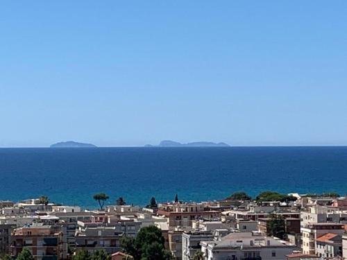 Une ville avec des maisons et l'océan en arrière-plan dans l'établissement Minerva Lodge - Panoramico centro storico Terracina, à Terracine