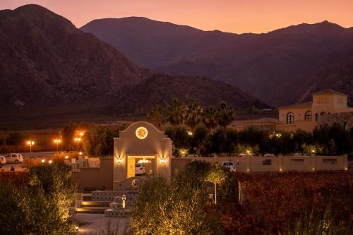 uma igreja com montanhas ao fundo à noite em Piattelli Wine Resort Hotel Cafayate em Cafayate