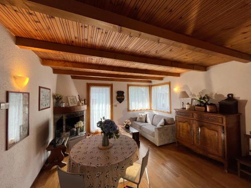 a living room with a table and a couch at Chalet Blanc "Le Flocon" in Courmayeur