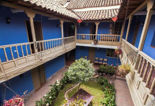 - une vue sur un bâtiment bleu avec un jardin dans l'établissement Tambo del Arriero Hotel Boutique, à Cusco