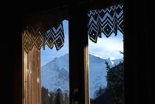 ein Fenster mit Blick auf einen schneebedeckten Berg in der Unterkunft Ferienwohnung Interlaken/Wilderswil in Wilderswil