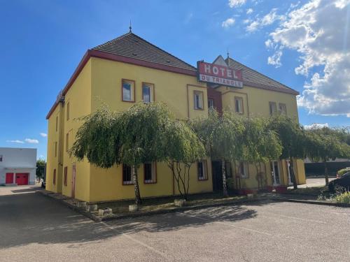 a yellow building with a sign on top of it at Hotel du Triangle in Talange