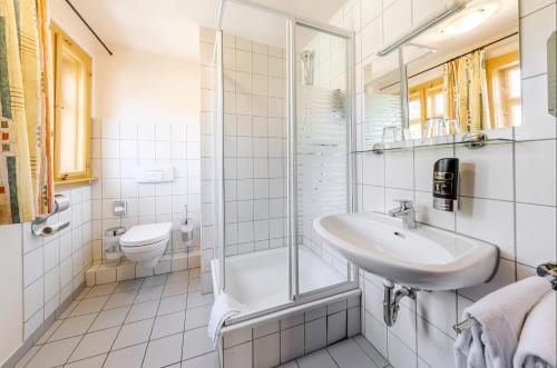 La salle de bains blanche est pourvue d'un lavabo et d'une douche. dans l'établissement Watzdorfer Geleitschenke und Herberge, à Weimar