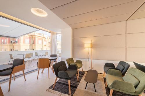 uma sala de espera com cadeiras e mesas em Eurostars Pórtico Alicante em Alicante