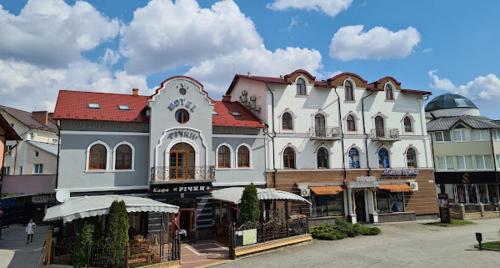 a large white building with a red roof at Richky Hotel in Truskavets