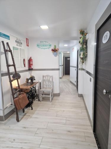 un pasillo con una mesa, una silla y una escalera en Hostal Boutique Luna de Gavín, en Cullera