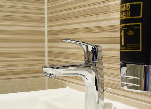 a bathroom sink with a chrome bathroom faucet at OLÉ Hotel in Hamburg