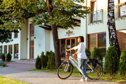 Eine Frau fährt Fahrrad auf einem Bürgersteig in der Unterkunft Regina in Druskininkai