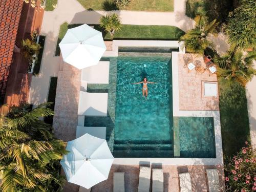 - une vue sur la piscine avec parasols dans l'établissement Terra Cottages Bali, à Uluwatu