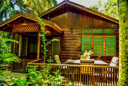 una cabina di legno con tavolo e sedie di fronte di Lighthouse Inn 2 a Negril