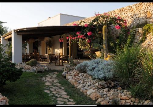 ein Haus mit einer Steinmauer und Blumen darauf in der Unterkunft Tenuta Negroamaro in Gallipoli