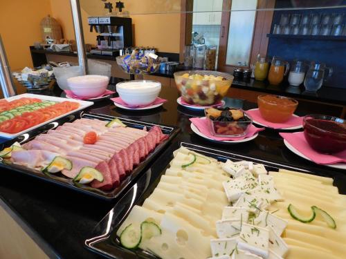 ein Buffet mit vielen verschiedenen Speisen auf der Theke in der Unterkunft Zentral Hotel in Bad Füssing