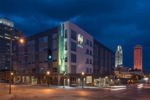 ein Gebäude in einer Stadt nachts mit grünem Licht in der Unterkunft EVEN Hotel Omaha Downtown - Old Market, an IHG Hotel in Omaha