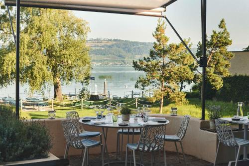 patio con tavolo, sedie e vista sul lago di Hotel Bad Murtensee a Murten