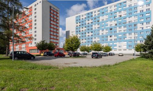 un estacionamiento con autos estacionados frente a edificios altos en Hotel Garni VŠB, en Ostrava