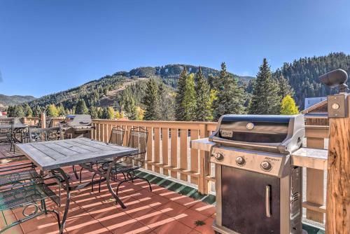 - un barbecue et une table de pique-nique sur une terrasse avec vue dans l'établissement Main St Red River Ski Condo with Mountain View!, à Red River