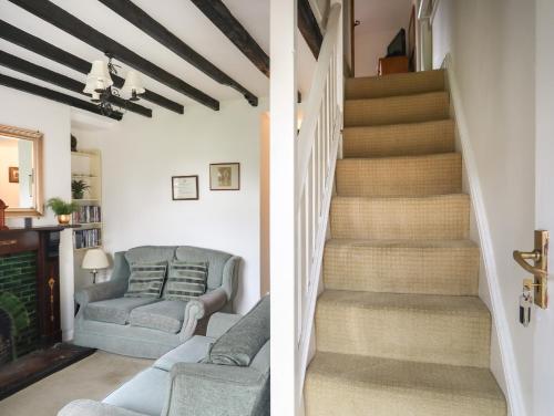 a staircase in a living room with a couch and a chair at Pen Dinas in Bangor