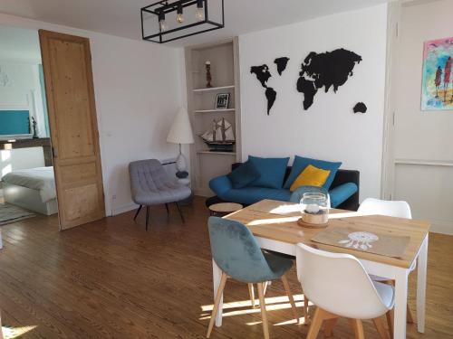 a living room with a table and a blue couch at Le Godefroy de Bouillon in Boulogne-sur-Mer