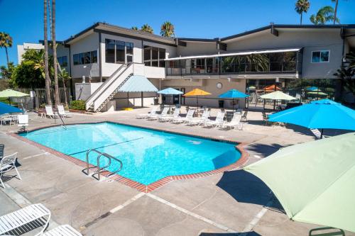 una piscina con sedie e ombrelloni di fronte a un edificio di San Clemente Inn a San Clemente