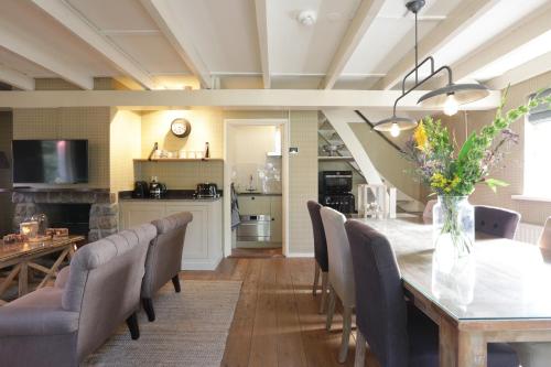 une salle à manger avec une table et des chaises ainsi qu'une cuisine dans l'établissement Lindenhof & Guesthouse, à Garderen