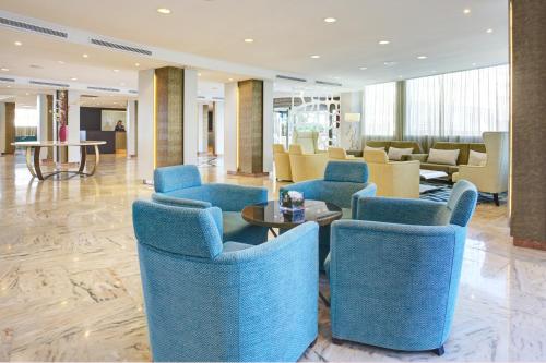 a lobby with blue chairs and tables in a building at Grupotel Acapulco Playa - Adults Only in Playa de Palma