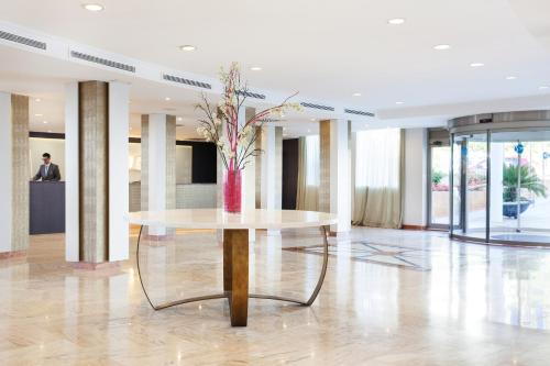 a lobby with a table with a vase of flowers on it at Grupotel Acapulco Playa - Adults Only in Playa de Palma