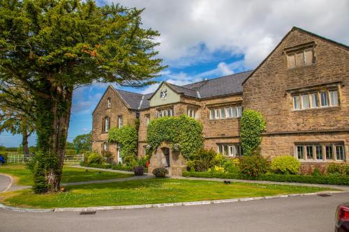 une grande maison en briques avec un arbre en face de celle-ci dans l'établissement Haighton Manor - Brunning and Price, à Grimsargh