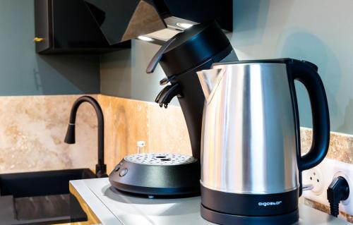 une cafetière assise sur une cuisinière dans l'établissement Le Cinq : Appartement Chic&Cosy, jardin privatif, à Vesoul