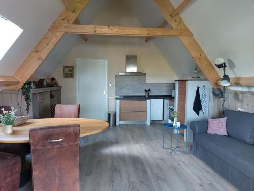 a living room with a table and a couch at Bed en Boomgaard in Giethoorn