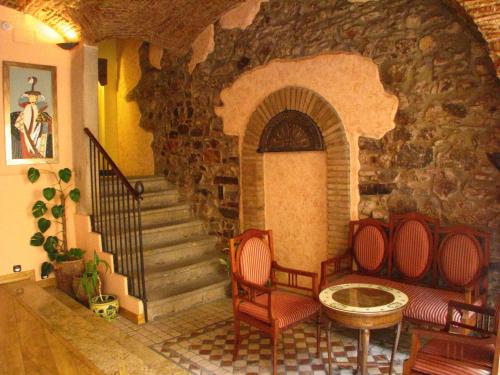 Cette chambre dispose d'un escalier en pierre avec deux chaises et une table. dans l'établissement Hotel Don Carlos Cáceres, à Cáceres