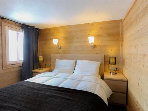 Schlafzimmer mit einem großen Bett und Holzwänden in der Unterkunft Duplex rénové à Val Thorens, 3 chambres, 6 pers, proche pistes et commerces - FR-1-637-49 in Val Thorens