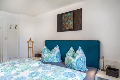 una camera da letto con un letto con cuscini blu e bianchi di Ferienwohnung Galerie Kaiser a Mayrhofen